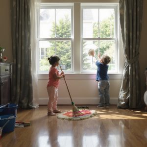 one child sweeping and one child washing windows
